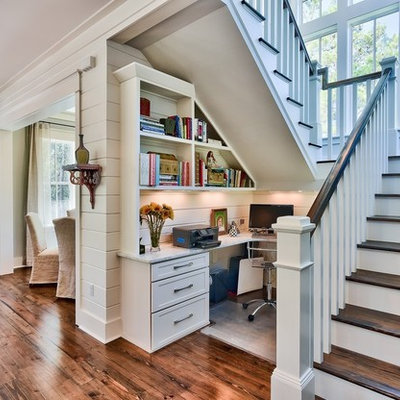 Example of a beach style built-in desk dark wood floor home office design in Miami with white walls
