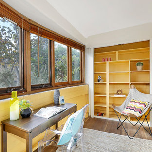 Design ideas for a mid-sized midcentury home office in Sydney with plywood floors, no fireplace, brown floor, yellow walls and a freestanding desk.