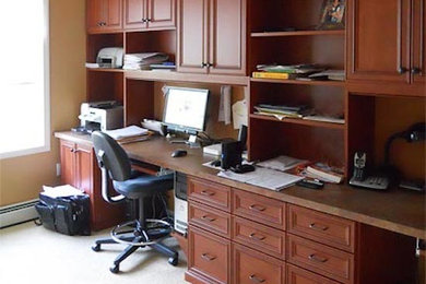 Example of a classic built-in desk carpeted home office design in Wichita with beige walls