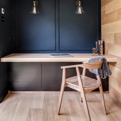 Inspiration for a contemporary built-in desk light wood floor home office remodel in London with black walls