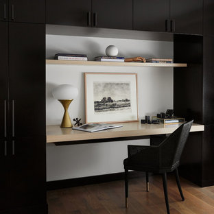 Mid-sized trendy built-in desk medium tone wood floor and brown floor study room photo in Chicago with white walls and no fireplace