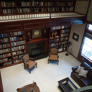 Expansive victorian home office in Other with a library, brown walls, carpet, a standard fireplace, a tile fireplace surround, a freestanding desk and grey floor.