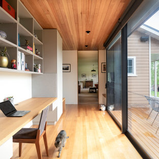 Modernes Arbeitszimmer mit weißer Wandfarbe, hellem Holzboden, Einbau-Schreibtisch, beigem Boden und Holzdecke in Hobart