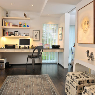 Trendy built-in desk dark wood floor home office photo in Other with white walls and no fireplace
