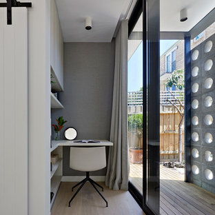 Inspiration for a midcentury study room in Melbourne with grey walls, light hardwood floors, no fireplace, a built-in desk and beige floor.