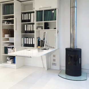 Inspiration pour un petit bureau design de type studio avec un mur blanc, un sol en bois clair, un poêle à bois et un bureau intégré.
