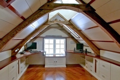 Imagen de despacho bohemio de tamaño medio con paredes blancas, suelo de madera en tonos medios, escritorio empotrado y suelo marrón