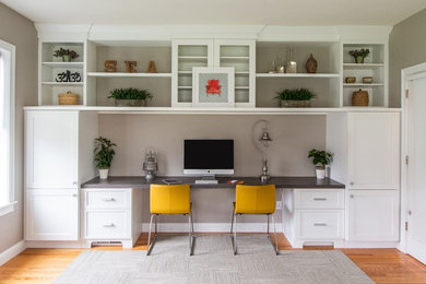 Ejemplo de despacho clásico renovado de tamaño medio con paredes grises, escritorio empotrado, suelo marrón y suelo de madera en tonos medios