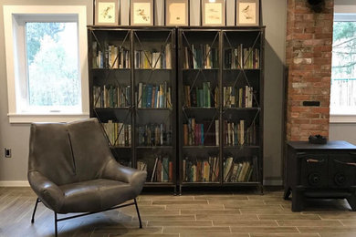 Foto de despacho moderno de tamaño medio sin chimenea con biblioteca, paredes grises, suelo de baldosas de porcelana, escritorio independiente y suelo gris