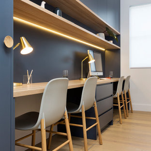 Inspiration pour un bureau design de taille moyenne avec un mur blanc, un sol en bois clair, un bureau intégré et un sol jaune.