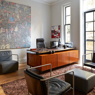Inspiration for a traditional home office in London with white walls, medium hardwood flooring, a freestanding desk and brown floors.