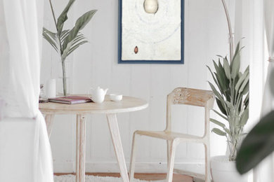 Ejemplo de despacho costero de tamaño medio con paredes blancas, suelo de madera clara, escritorio independiente y suelo beige