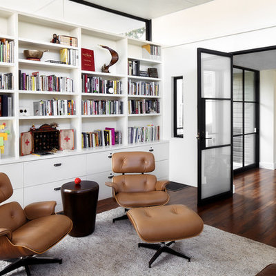 Example of a mid-sized trendy freestanding desk dark wood floor and brown floor study room design in Austin with white walls and no fireplace