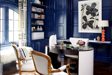 Foto de despacho bohemio con paredes azules, suelo de madera oscura y escritorio independiente