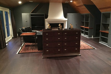 Example of a large trendy built-in desk dark wood floor home studio design in Minneapolis with green walls, a standard fireplace and a plaster fireplace