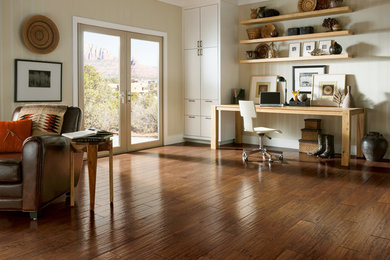 Imagen de despacho de estilo americano grande sin chimenea con paredes blancas, suelo de madera en tonos medios y escritorio independiente