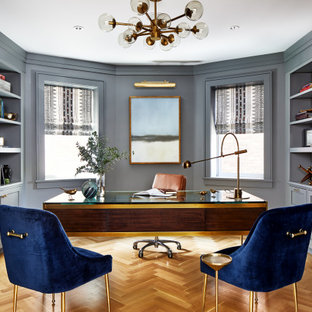 Idéer för att renovera ett stort vintage hemmabibliotek, med grå väggar, ett fristående skrivbord, brunt golv och mellanmörkt trägolv