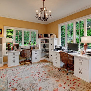 Inspiration pour un bureau rustique avec un sol en bois brun, un bureau indépendant et un mur jaune.
