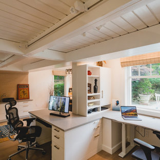 Modernes Arbeitszimmer mit weißer Wandfarbe, braunem Holzboden, Einbau-Schreibtisch, braunem Boden, freigelegten Dachbalken und Holzdielendecke in Boston