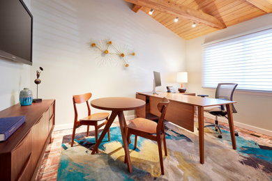 Inspiration for a mid-sized 1950s freestanding desk brick floor study room remodel in Orange County with white walls