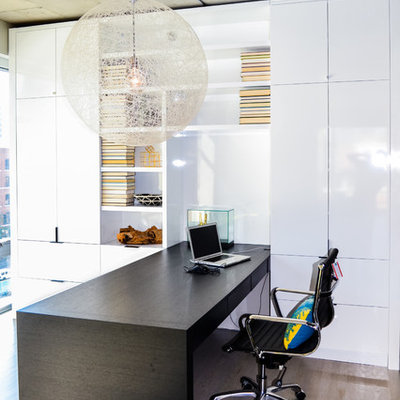 Mid-sized urban built-in desk light wood floor study room photo in Chicago with white walls and no fireplace