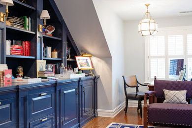 Medium sized traditional study in New York with blue walls, light hardwood flooring, a freestanding desk and beige floors.