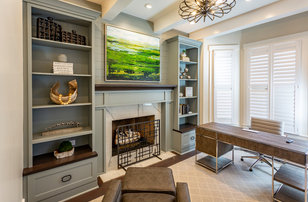 Inspiration for a mid-sized transitional freestanding desk medium tone wood floor and brown floor study room remodel in Cincinnati with gray walls, a standard fireplace and a stone fireplace