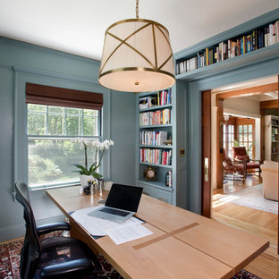 Arts and crafts study room in Boston with blue walls, light hardwood floors, no fireplace and a freestanding desk.