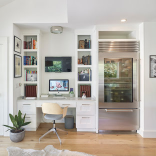 Home office - traditional built-in desk light wood floor and beige floor home office idea in San Francisco with white walls