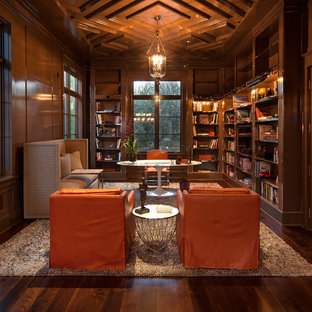 Klassisches Arbeitszimmer mit Arbeitsplatz, brauner Wandfarbe, dunklem Holzboden, freistehendem Schreibtisch und braunem Boden in Los Angeles