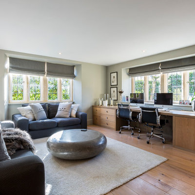 Study room - large country built-in desk medium tone wood floor study room idea in Gloucestershire with gray walls and no fireplace