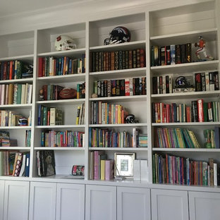 Klassisk inredning av ett litet arbetsrum, med ett bibliotek, beige väggar, mellanmörkt trägolv och brunt golv
