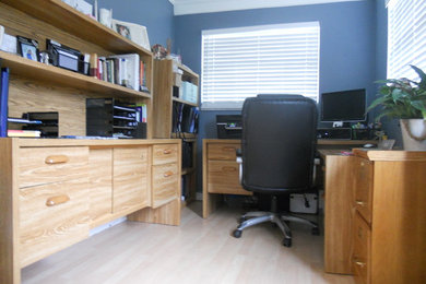 Foto de despacho pequeño con paredes azules y escritorio independiente