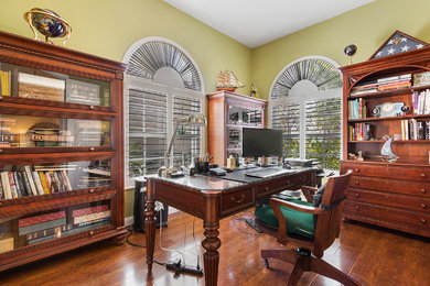 Mid-sized elegant freestanding desk dark wood floor and brown floor study room photo in Miami with green walls and no fireplace