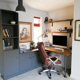 This is an example of a medium sized contemporary study in West Midlands with grey walls, laminate floors, a built-in desk and white floors.