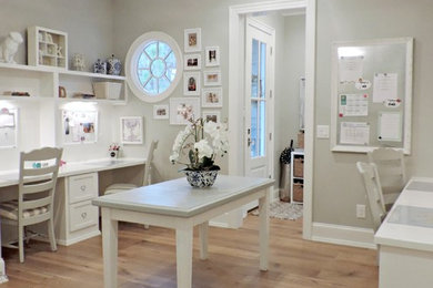 Diseño de despacho clásico de tamaño medio con paredes grises, suelo de madera clara y escritorio empotrado
