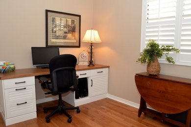 Mid-sized elegant built-in desk medium tone wood floor study room photo in Tampa with beige walls and no fireplace