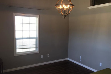 Mittelgroßes Klassisches Arbeitszimmer ohne Kamin mit grauer Wandfarbe, Laminat, freistehendem Schreibtisch und braunem Boden in Boise