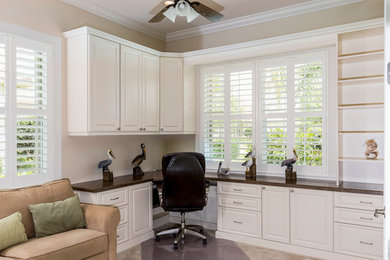 Imagen de despacho clásico con paredes beige y escritorio empotrado
