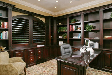 Ejemplo de despacho tradicional grande sin chimenea con paredes amarillas, moqueta y escritorio empotrado