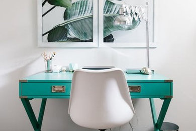 Ejemplo de despacho ecléctico pequeño con paredes blancas, suelo laminado, escritorio independiente y suelo gris
