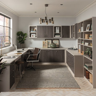 This is an example of a contemporary study with grey walls, a freestanding desk and beige floors.