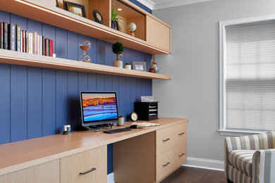 Foto de despacho tradicional renovado de tamaño medio sin chimenea con paredes azules, suelo de madera oscura, escritorio empotrado y suelo marrón