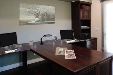 Home office - contemporary built-in desk dark wood floor and brown floor home office idea in Phoenix with gray walls