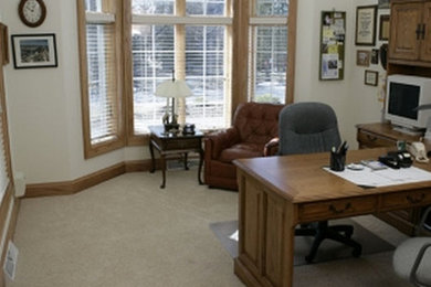 Diseño de despacho tradicional de tamaño medio sin chimenea con paredes blancas, moqueta, escritorio empotrado y suelo beige