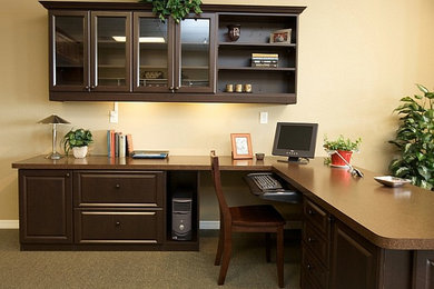 Ejemplo de despacho clásico de tamaño medio sin chimenea con paredes beige, moqueta, escritorio empotrado y suelo marrón