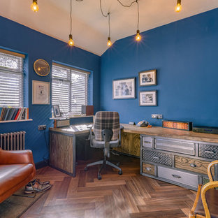 Inspiration for an industrial home office in Hertfordshire with blue walls, dark hardwood flooring, a built-in desk and brown floors.