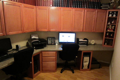 Foto de despacho de tamaño medio con paredes beige, suelo de madera en tonos medios y escritorio empotrado