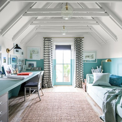 Example of a beach style built-in desk brown floor and medium tone wood floor home office design in New York with blue walls and no fireplace