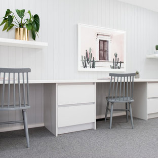 Idéer för mellanstora funkis hemmabibliotek, med grå väggar, heltäckningsmatta, ett inbyggt skrivbord och grått golv